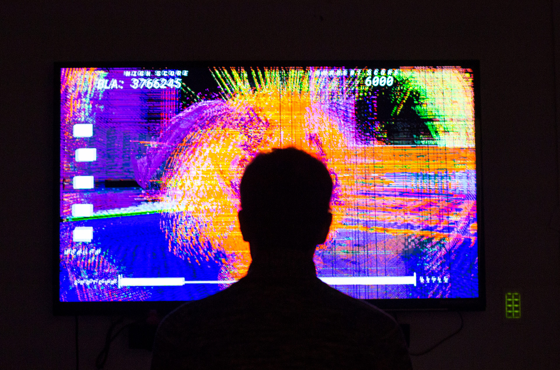 Player stands in front of glitch art game.