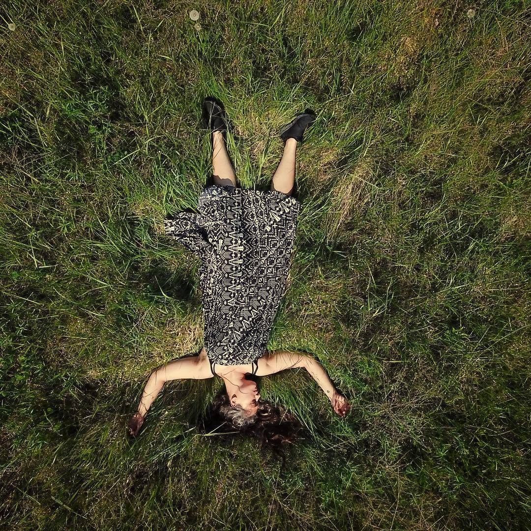 Aerial photo of Ava Ansari laying in a field of grass