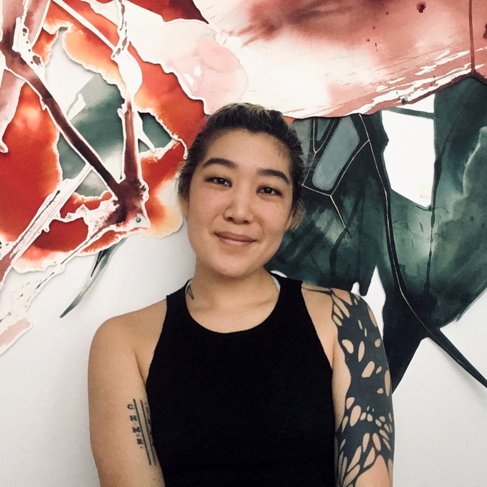 GB Kim in black tank top in front of abstract mural