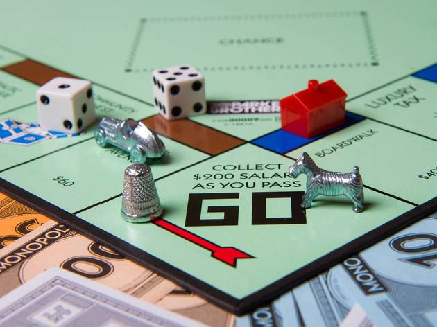 Closeup of a Monopoly board with two dice, and three players' pieces