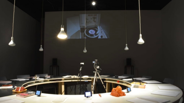 Round table in the center of the room with cameras and papers on top