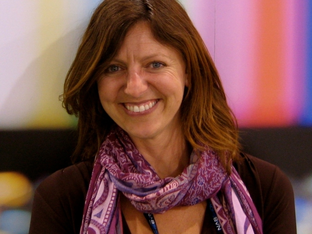 Jennifer Holt, woman wearing a pink and purple scarf, smiling