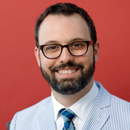 Headshot of Chris Kairalla in a suit and glasses