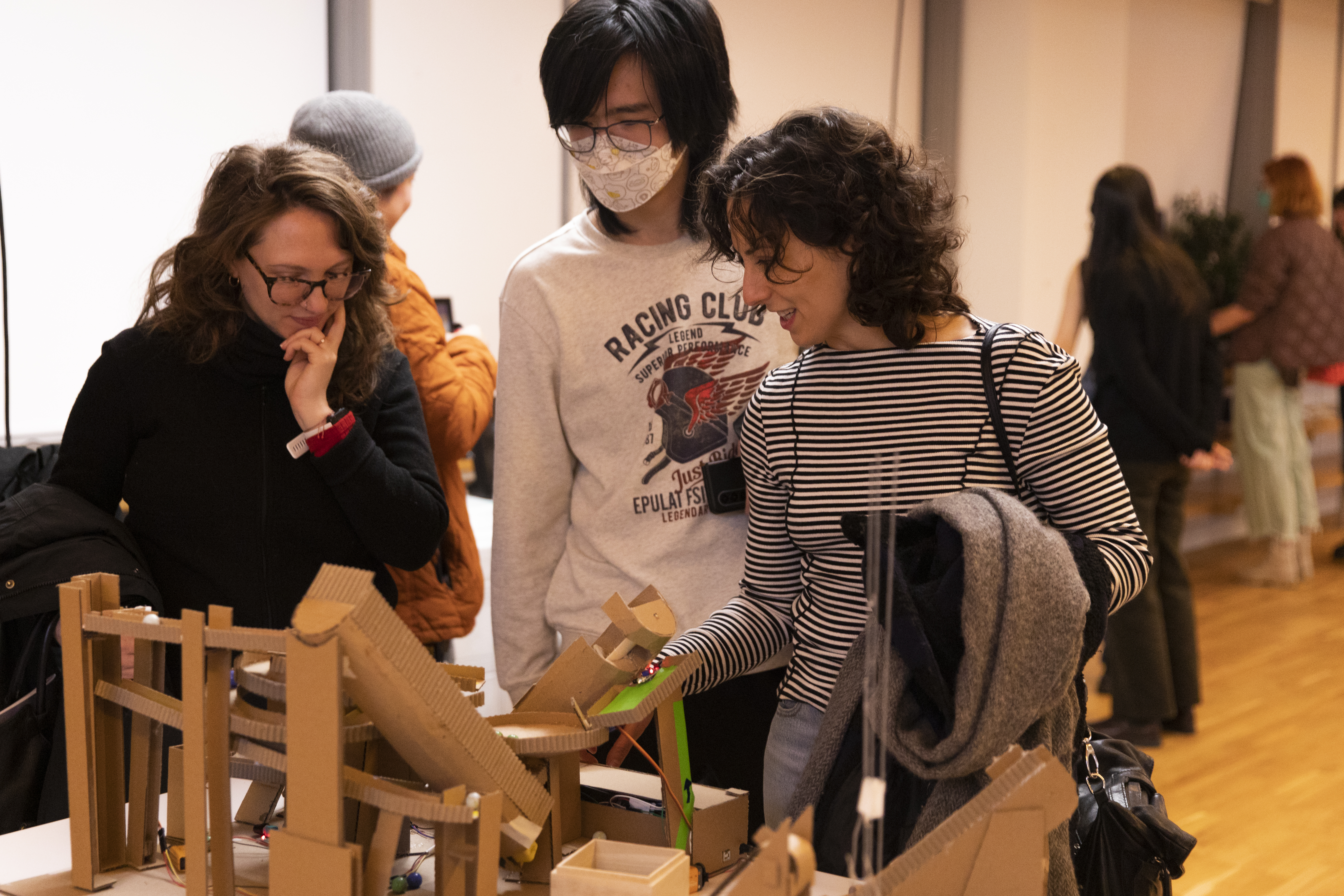 People huddled around a project consisting of platforms made out of cardboard