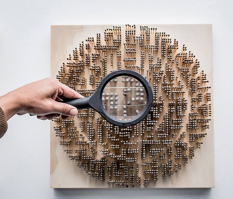 A circle arrangement of standing matchsticks, with someone holding a magnifying glass in the center