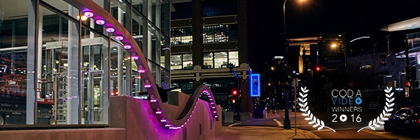 a pink curvy structure with lights set up outside