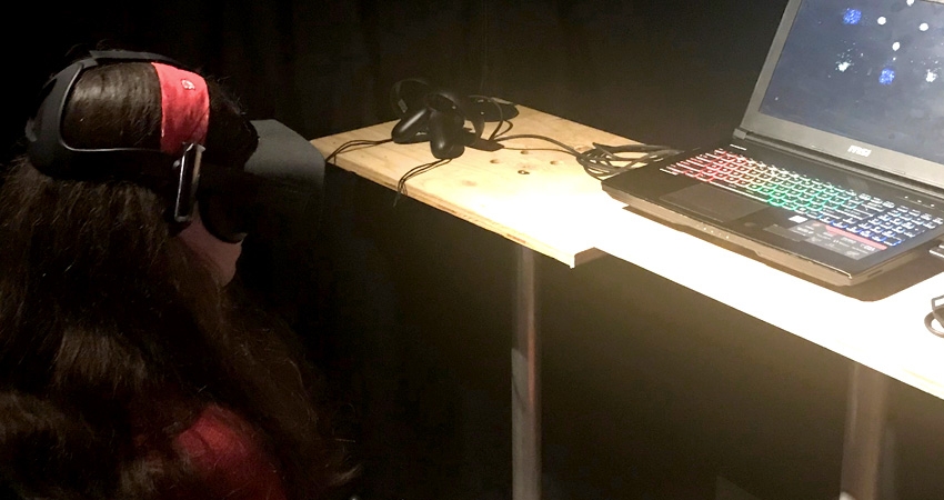 Women uses VR headset in front of computer at the ITP Spring Show 2018