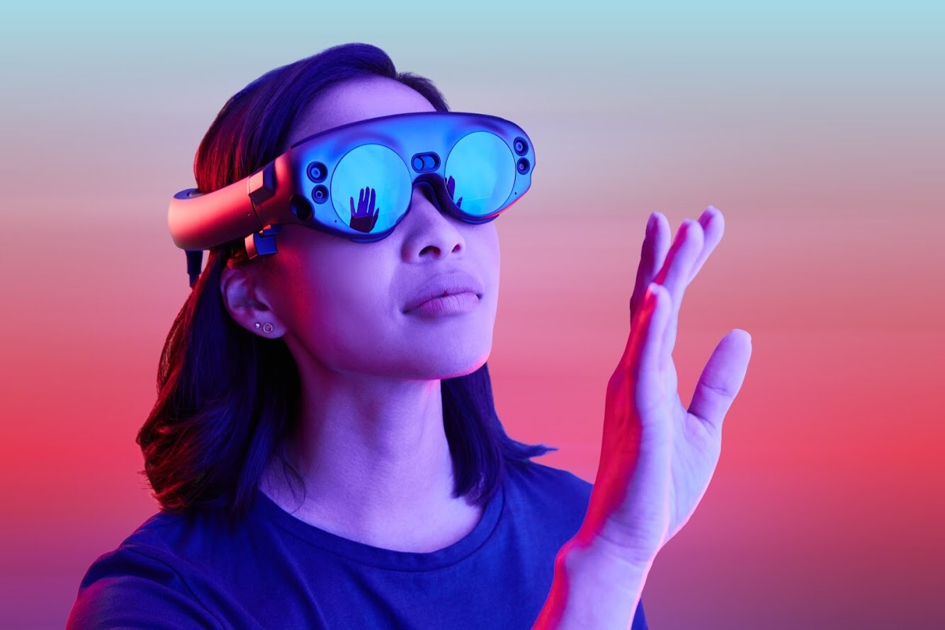 Woman looks through VR lenses, lifting hand as if to see something only she can see