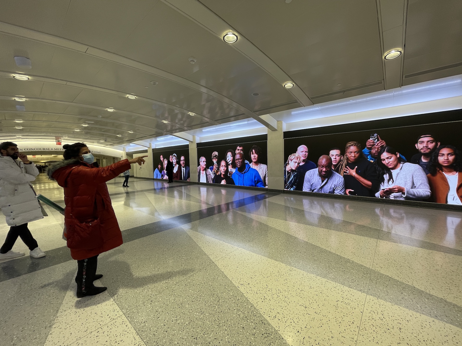 Person pointing at digital panels of art showing people