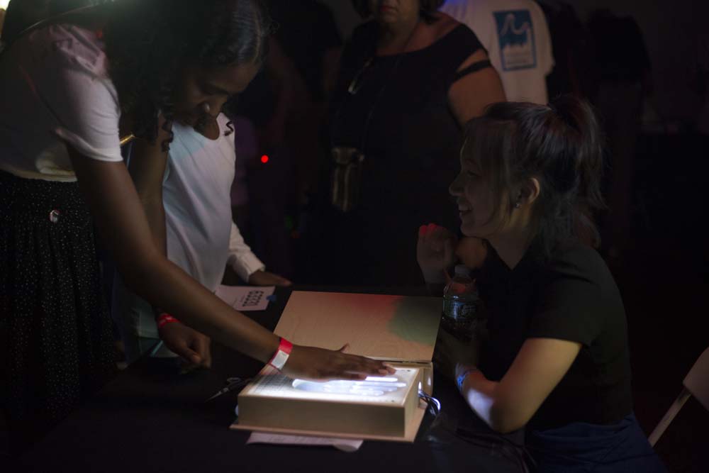 A person places their hand on a light up box