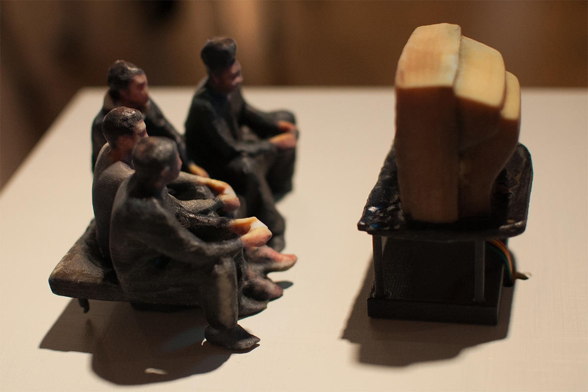 a miniature sculpture of a group of people watching TV