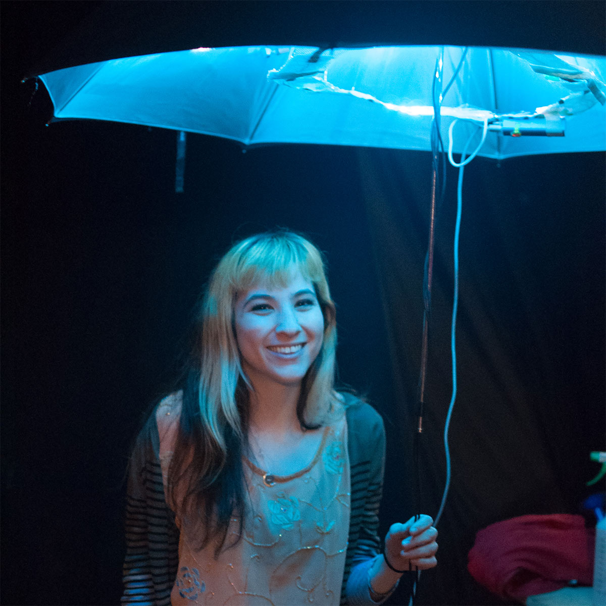 a woman holding an umbrella with lights illuminating it from within