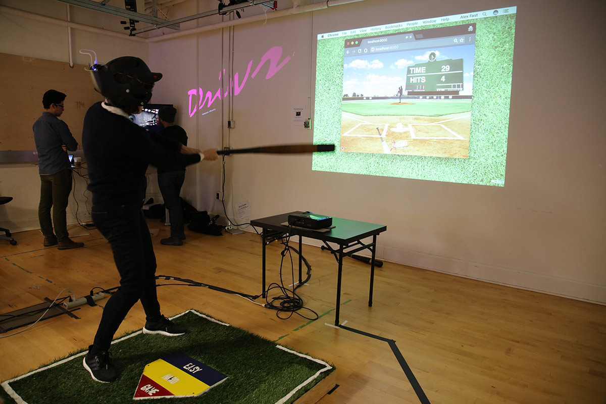 a person wearing baseball helmet and bat hitting a virtual pitch