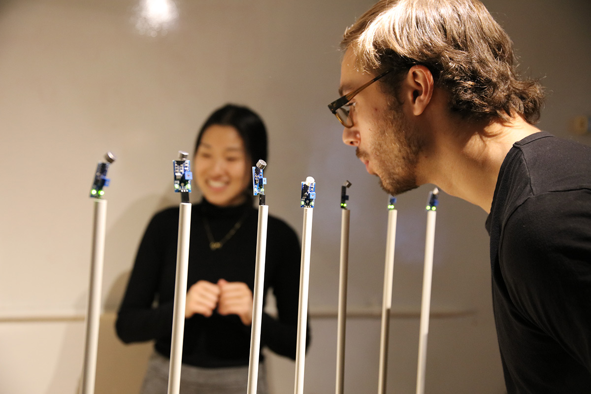 a person blowing into sensors on sticks