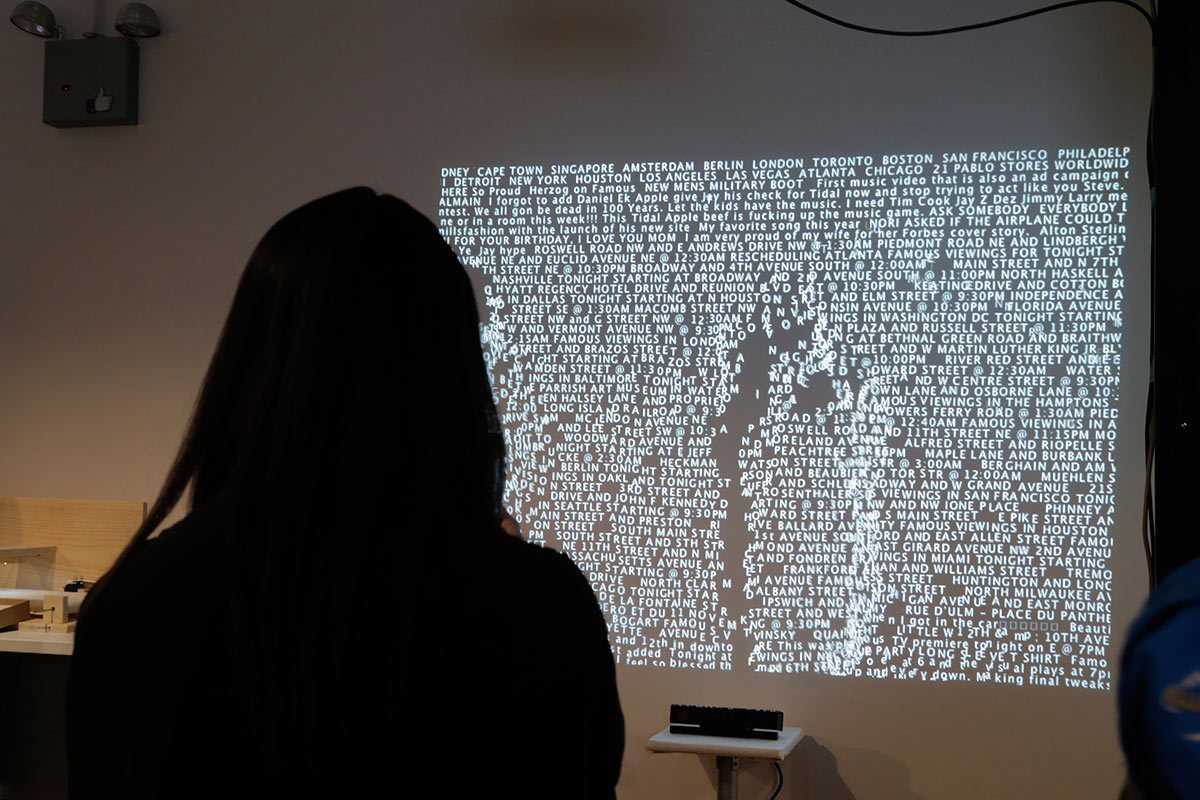 a silhouette of a person looking at a projection filled with words and their shape is disturbing the words