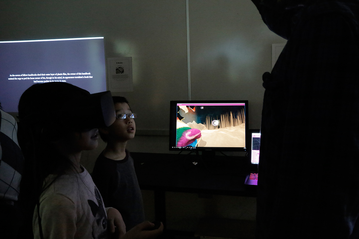 kids wearing VR googles with a monitor showing the landscape they are seeing