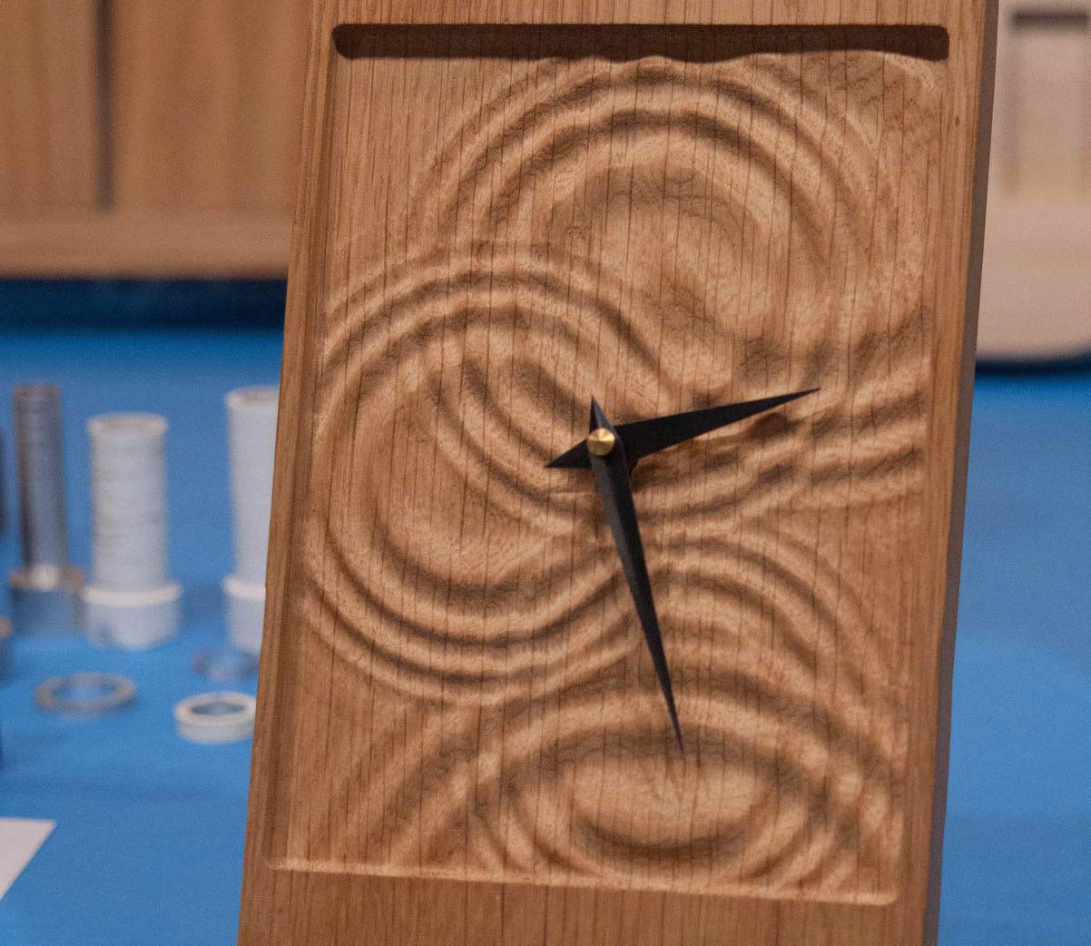 a wooden clock with a ripple design that looks like water drops