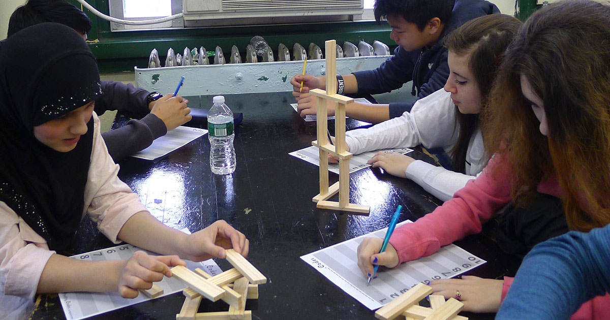 a group of young people building with wooden blocks