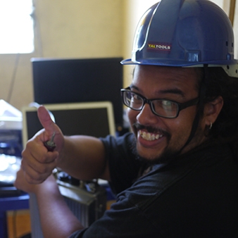 Headshot of Edwin Reed-Sanchez with a big smile, hardhat and a thumbs up