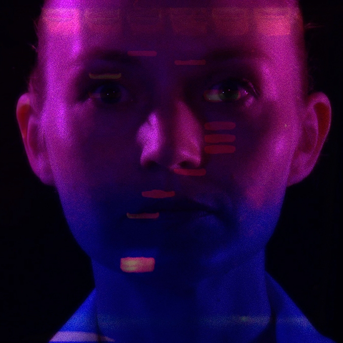 Headshot of Heather Dewey-Hagborg with abstract pink and blue lighting on her face 