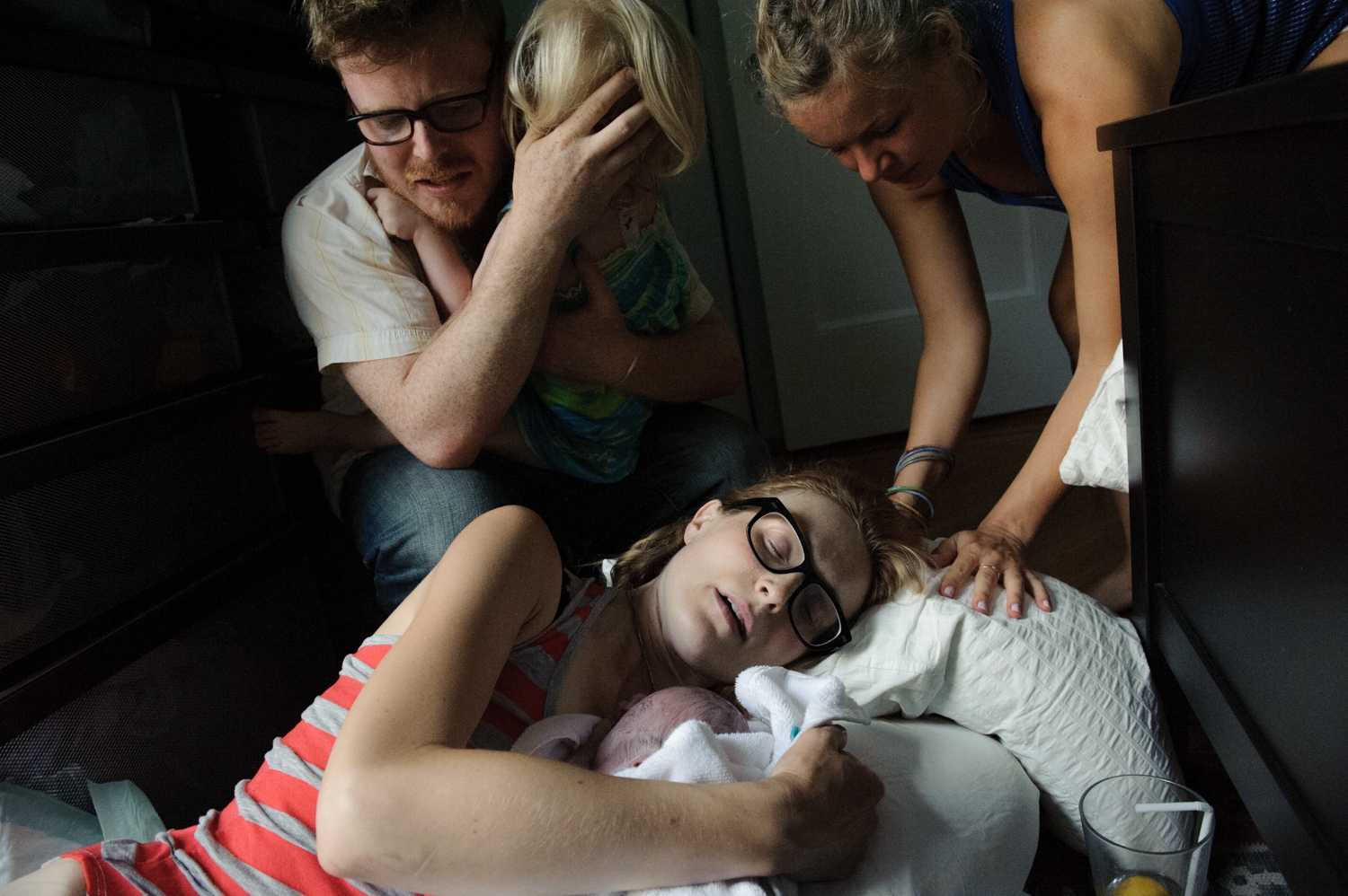 Scene of a home birth with mother, family, and newborn