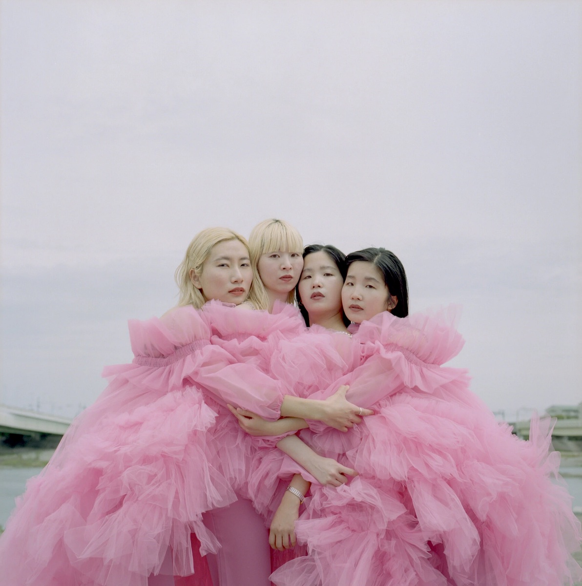 portrait of four band members dressed in pink frilling toile