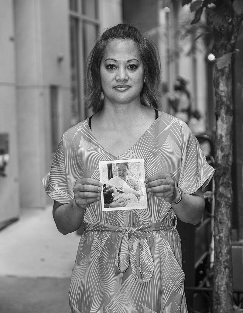 portrait of a person named Donna holding portrait of a Filipinx jailed member