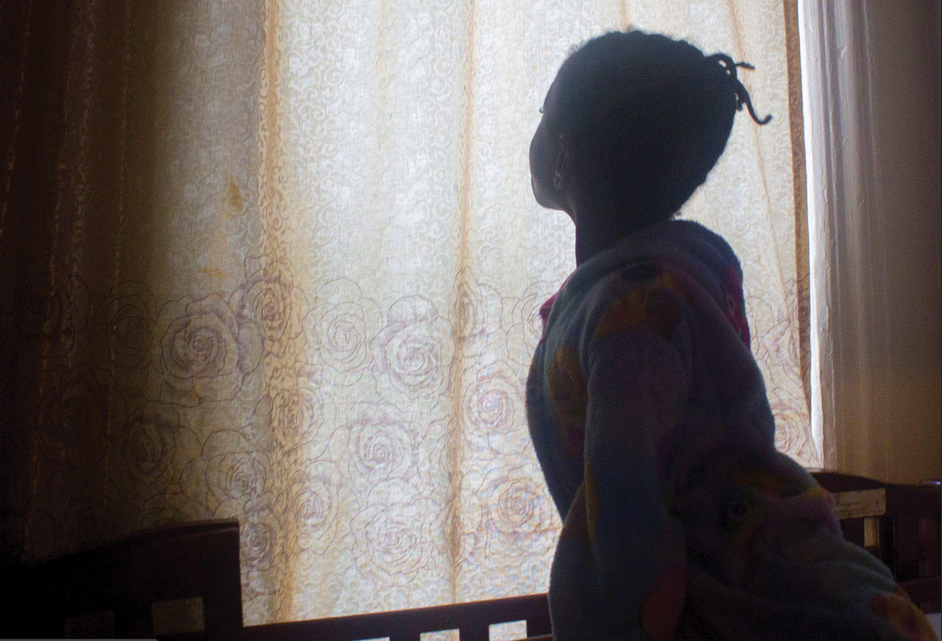 Silhouette of a young girl at a window