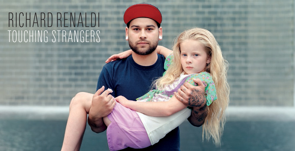 A photo by Richard Renaldi depicting two strangers; An adult male holding a young girl in his arms. 