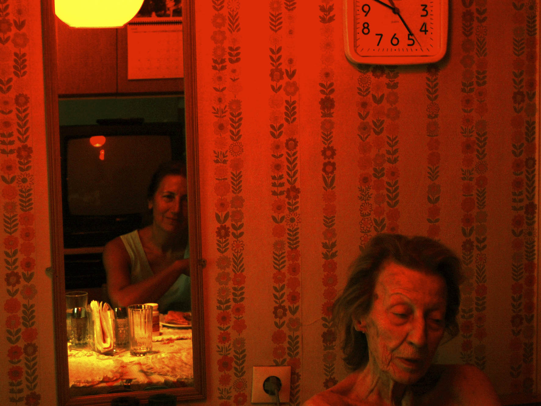 old woman in red-lit room