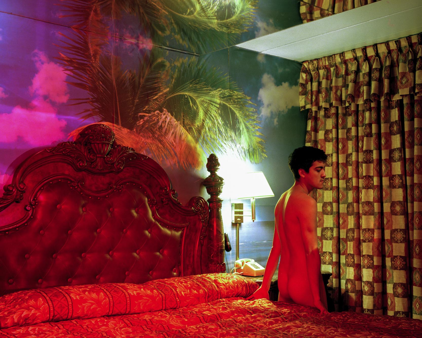 portrait of naked man in colorful motel room