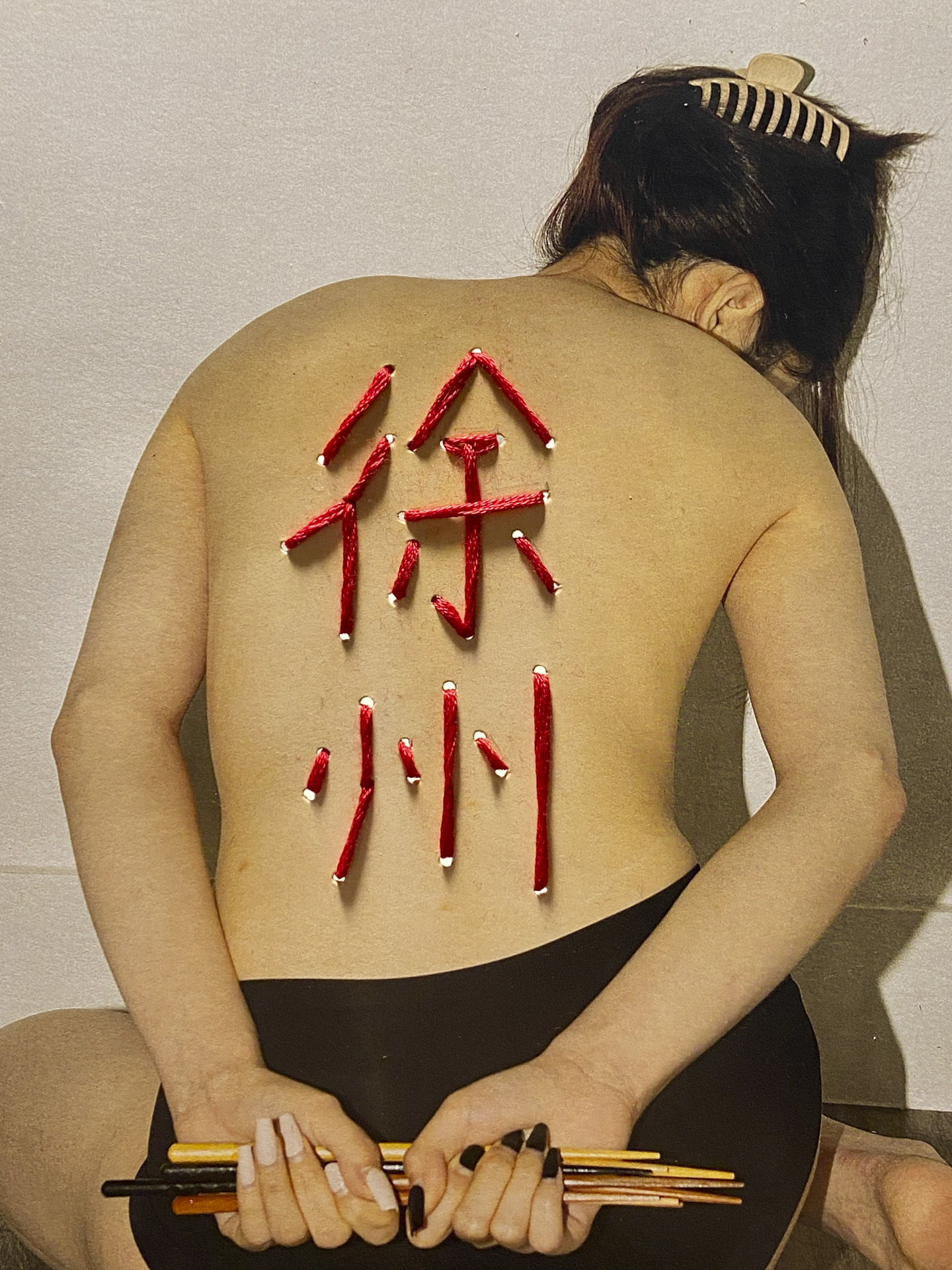 photo of a human's back with non-english characters written on their back