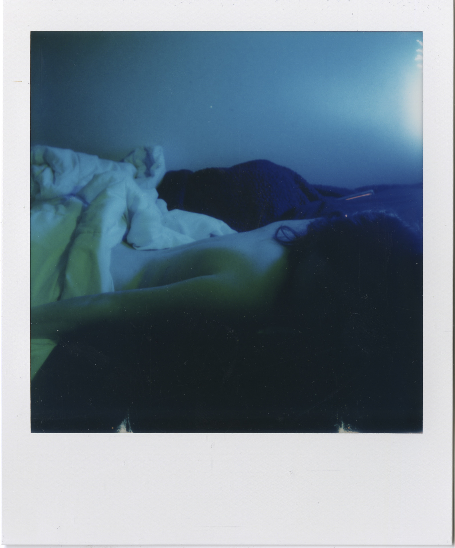 blue tone portrait of a person lying a bed