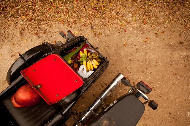 Trunk on a motorbike with fresh fruit and vegetables.