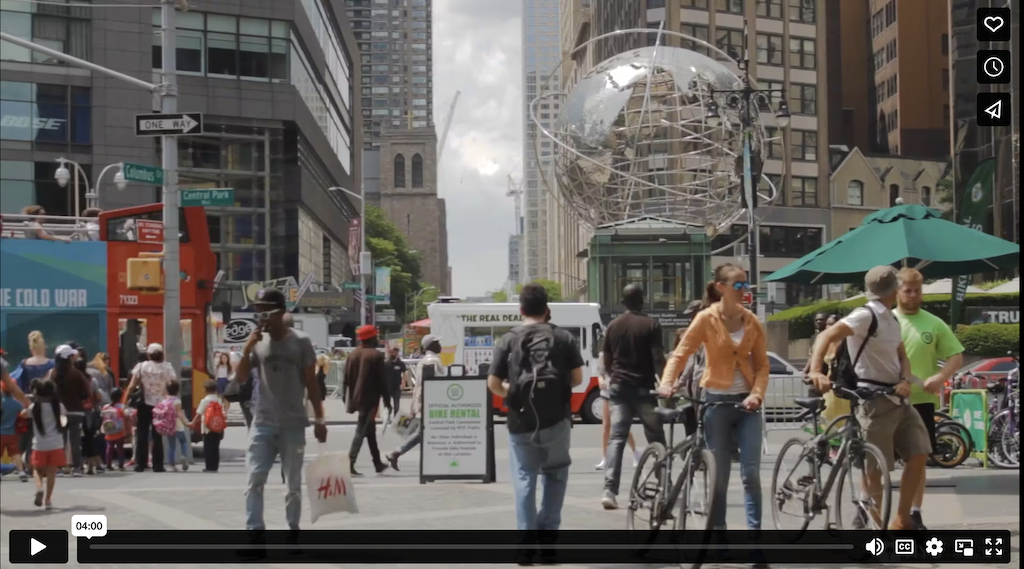 Still video image of people walking through Columbus Circle in Manhattan on a sunny day