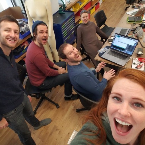 A group gathered a round a table working and smiling