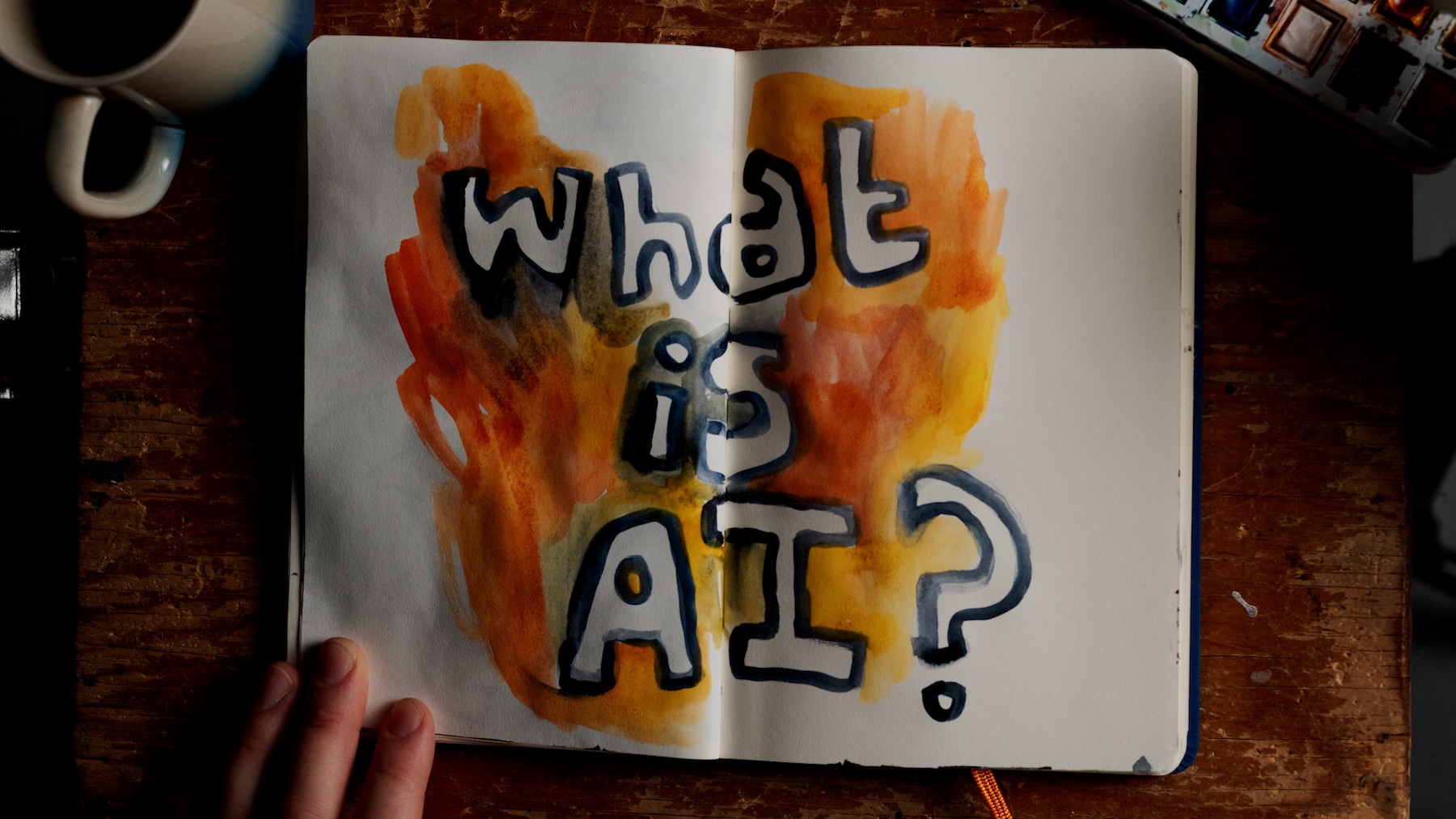 Blank pages in a notebook with WHAT IS AI? drawn across them in paint