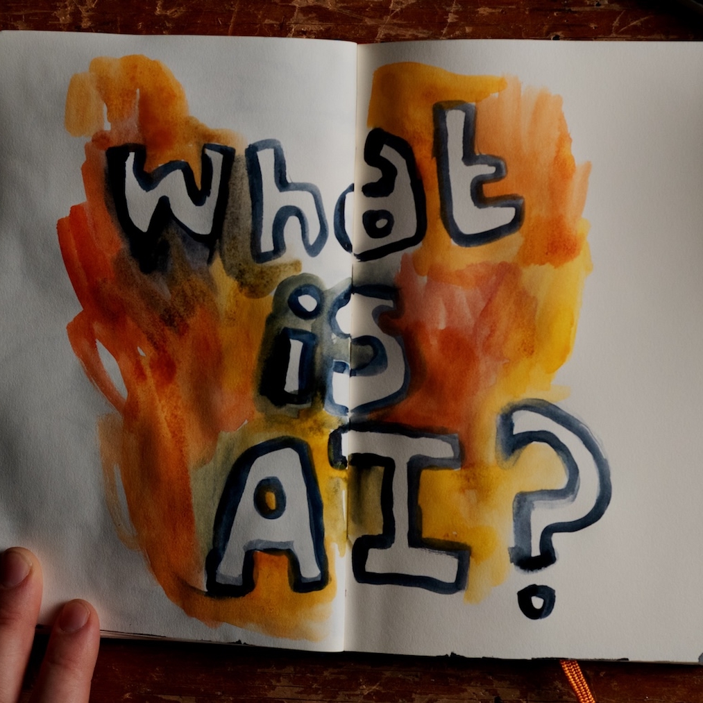 Blank pages in a notebook with WHAT IS AI? drawn across them in paint