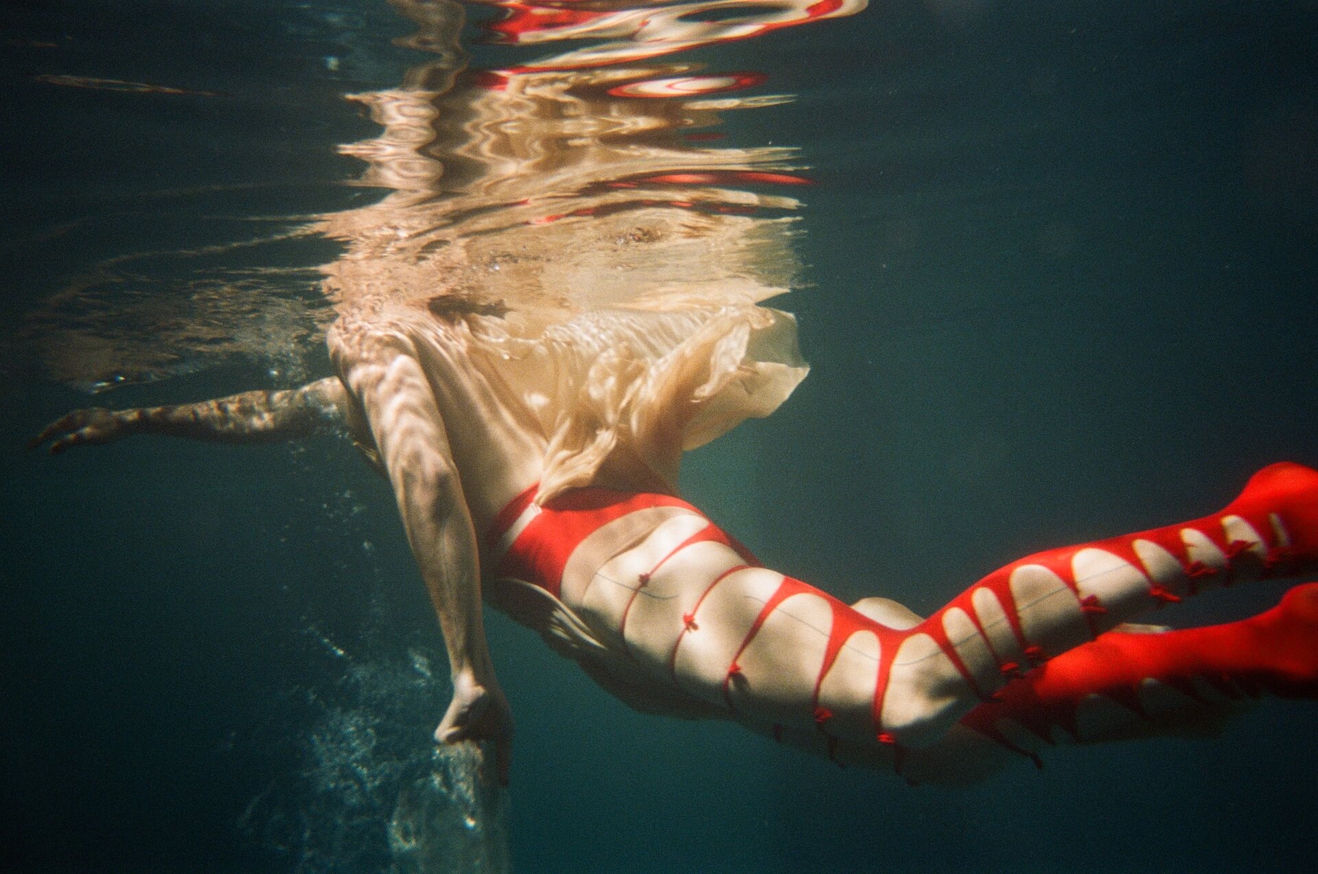 Person swimming wearing red ripped tights