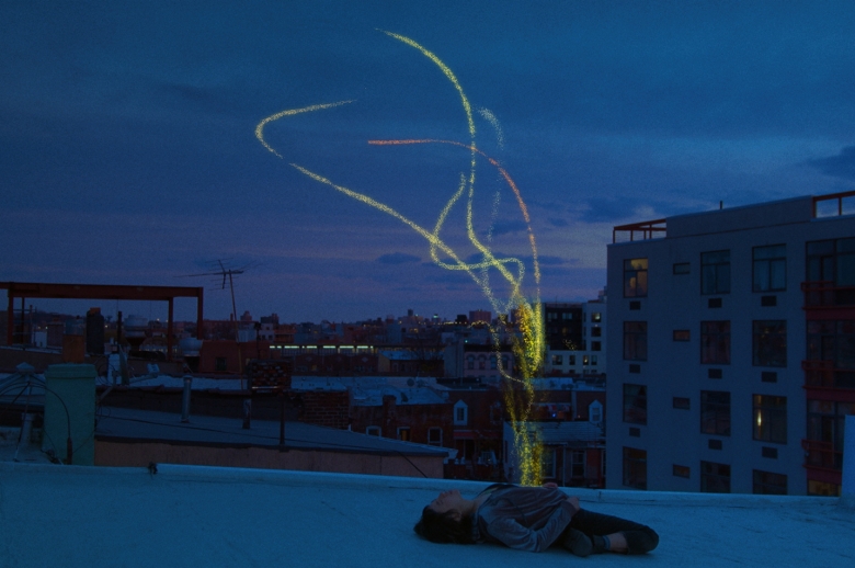 a person lays back on a roof top with sparkles emerging from their body