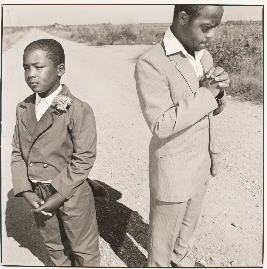A photo of two young boys praying on a Mississippi country road.