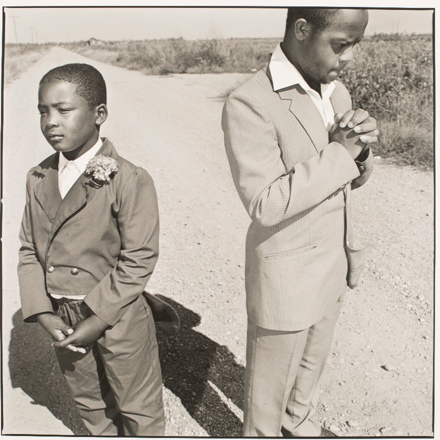 Image of two boys on a country road by Mary Ellen Mark, “Two Boys Praying in the Road”,  Tunica, Mississippi, 1990.