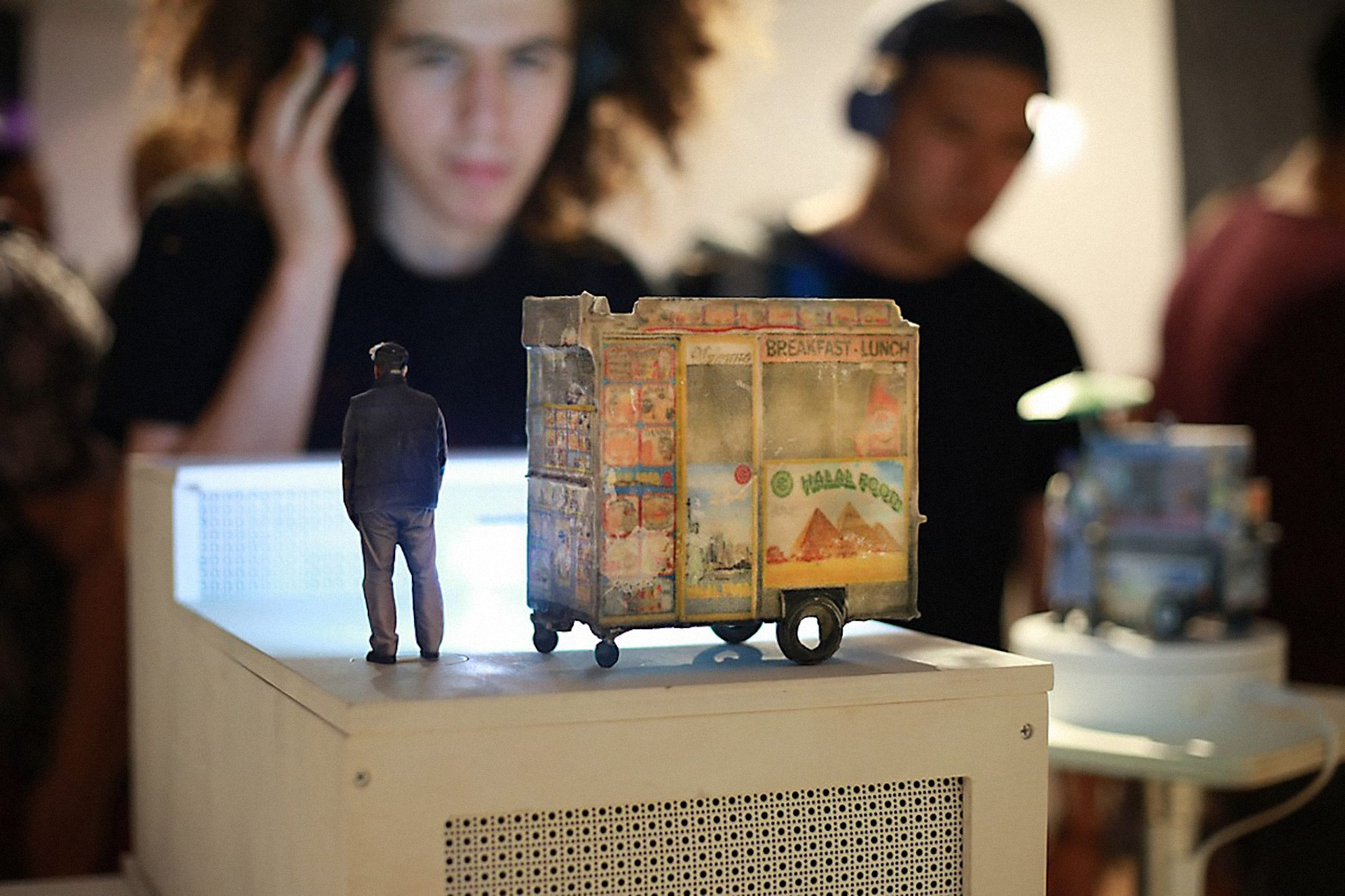 Image from ITP Show of student looking at miniature sculpture of an outdoor food truck