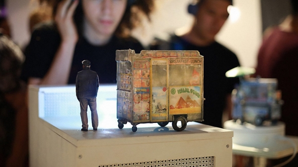 Image from ITP Show of student looking at miniature sculpture of an outdoor food truck
