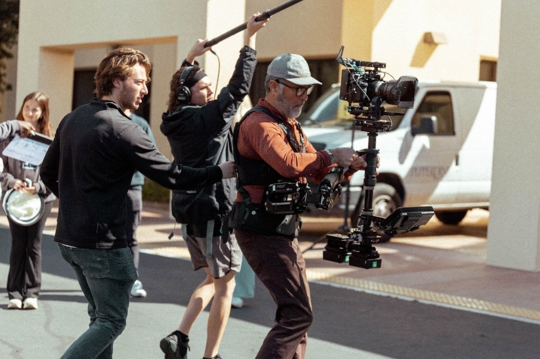 Crew on the set of a film shoot with camera and sound equipment.