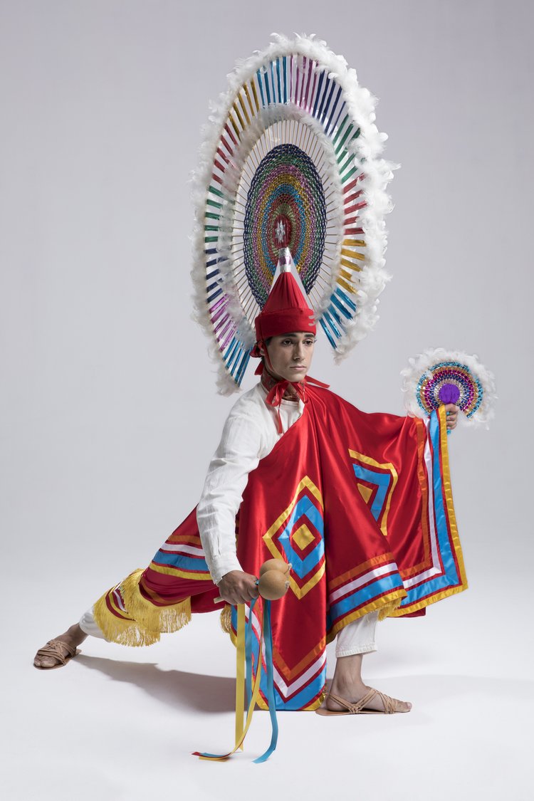 A picture of a man standing in a power stance in Mexican traditional wear.