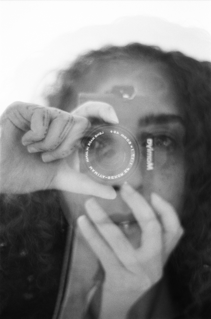 A black-and-white photo of Jenna Hamed simulating taking a picture.