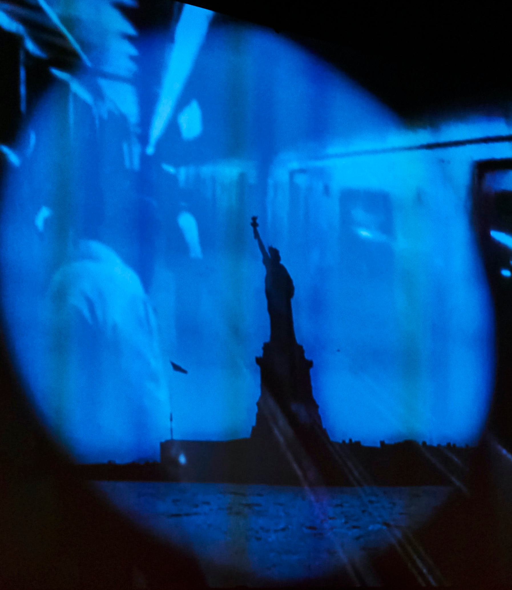 blue projection with statue of liberty shadow
