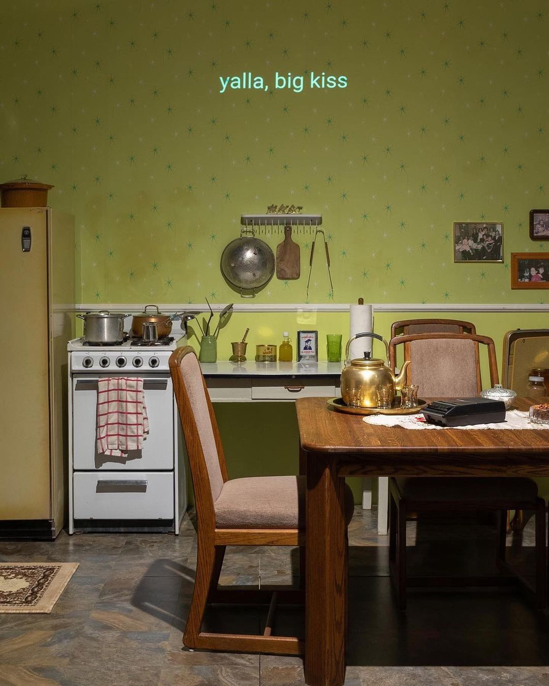 Still from “the sound of your voice is home”,  kitchen image with "yalla big kiss" written in the center