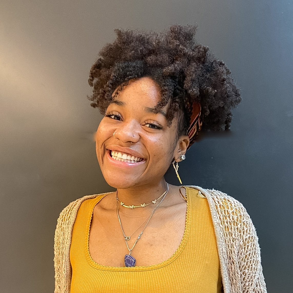 Geanina Riley headshot in yellow shirt